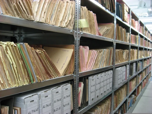 Documents familiaux empilés à trier et numériser